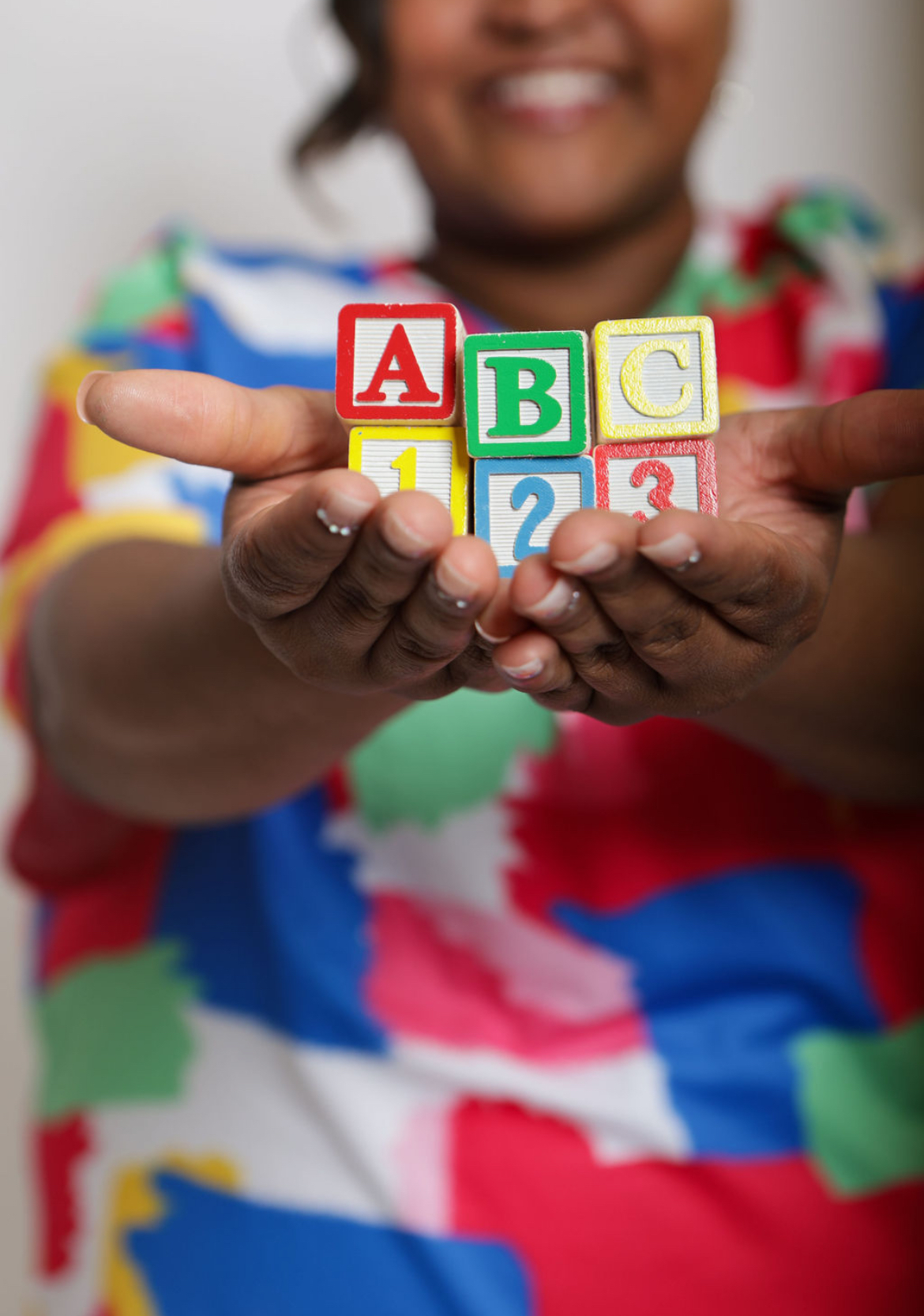 Ms. Hanna holding wooden ABC and 123 blocks
